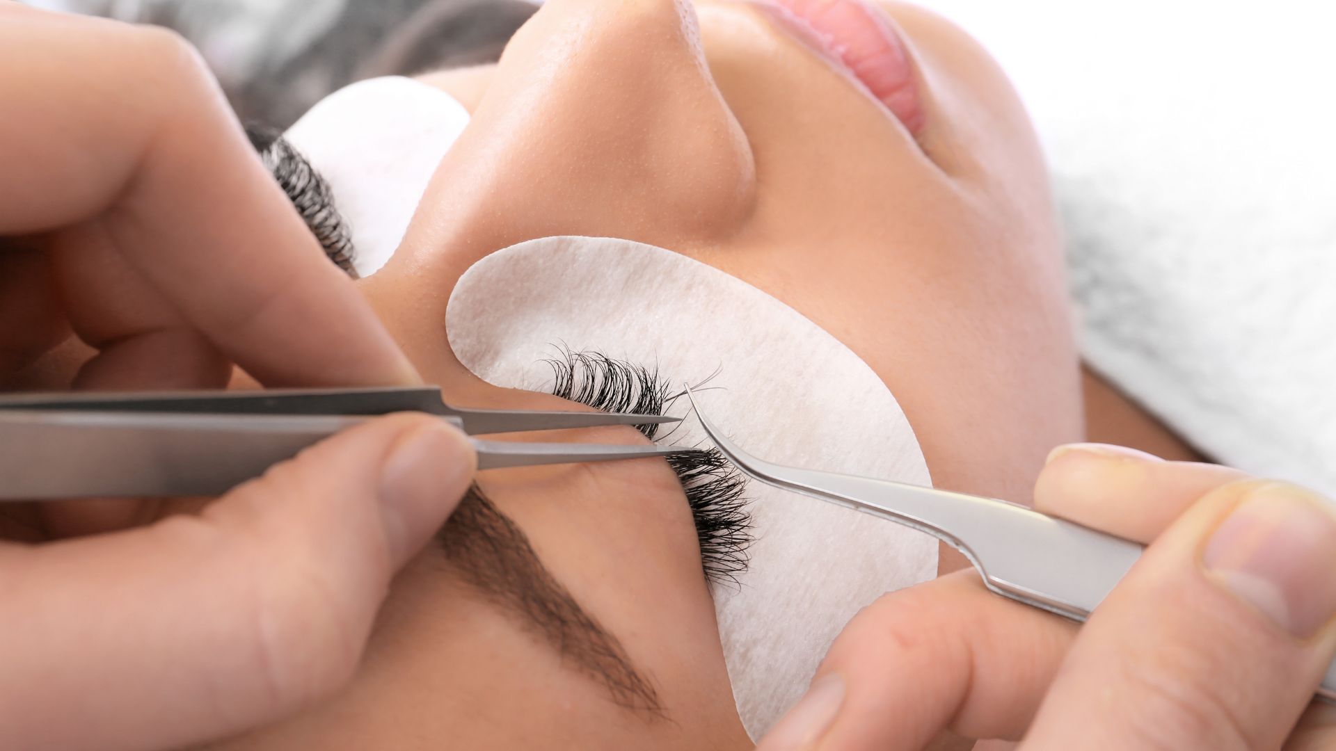 Eyelash extension application with tweezers and protective eye pad