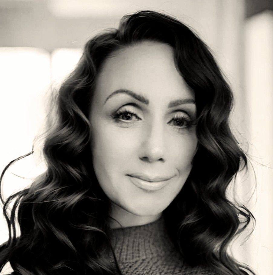 Black and white portrait of woman with wavy hair and soft smile