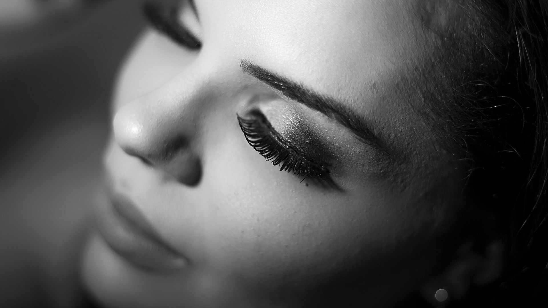 Close-up of closed eye with long eyelashes in black and white